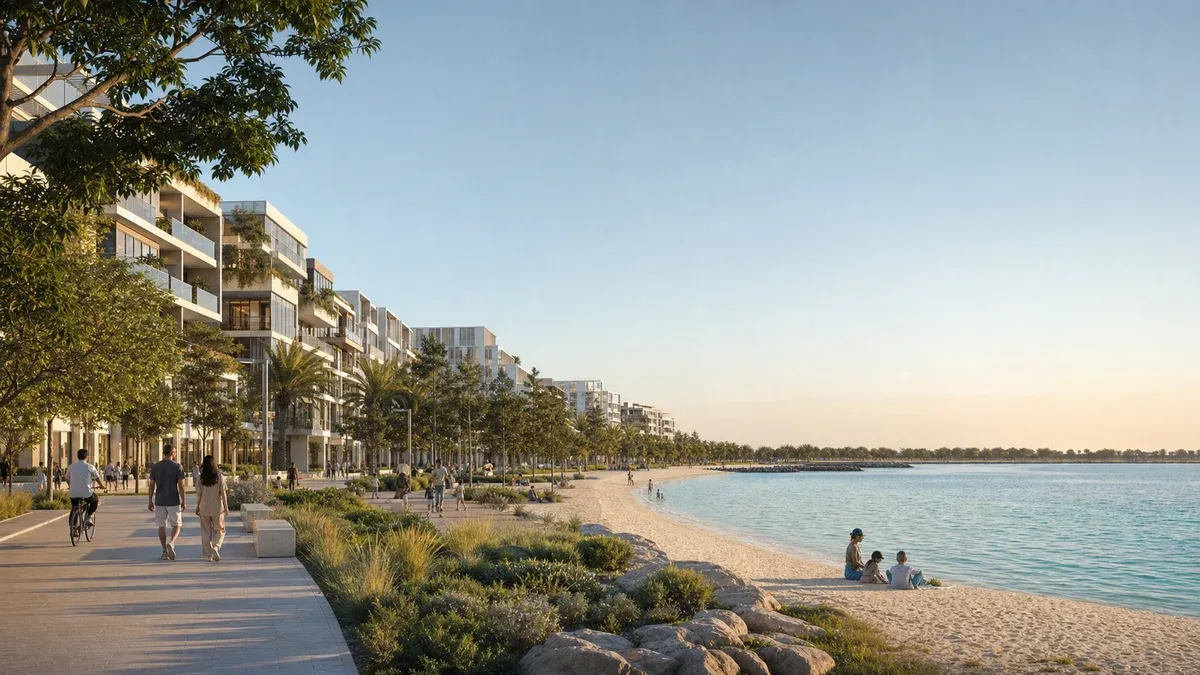 A photorealistic view across Yas Island’s northern waterfront, showing a new mid-rise residential district with a beach, tree-lined promenade, parks and families beside the water.