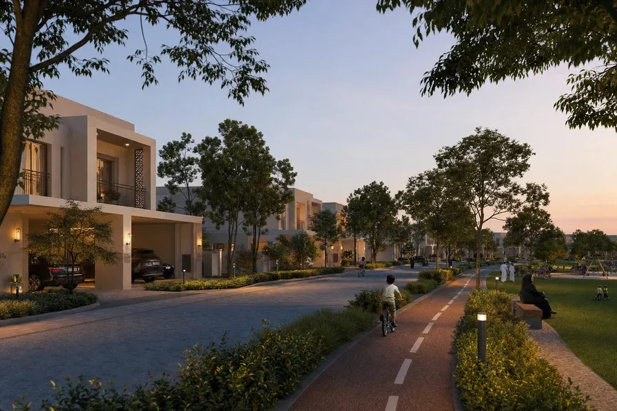 A photorealistic wide shot of a UAE family villa community at dusk, two-storey townhouses lining a tree-shaded street, cycling path and central green park visible.